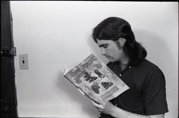 Marty Liebmann of Free Spirit Press crew reading a copy of the magazine (vol.             1, 4), ca. 1973