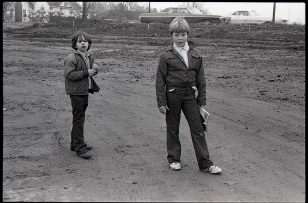 Two boys standing in a muddy lot, ca. December 13, 1972