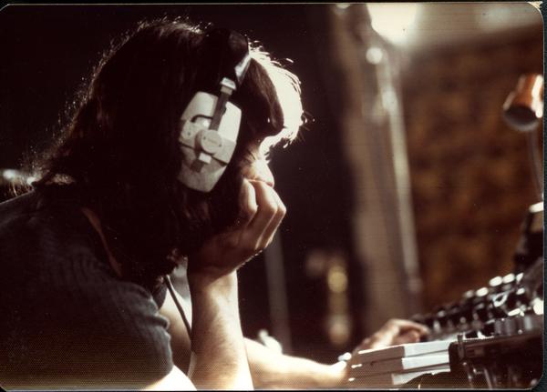 Jimmy Skiathitis in headphones at mixing board in recording studio, ca. 1973